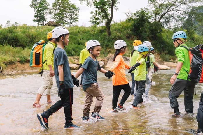 Group wearing helmets and life jackets entering Tu Lan cave in Phong Nha